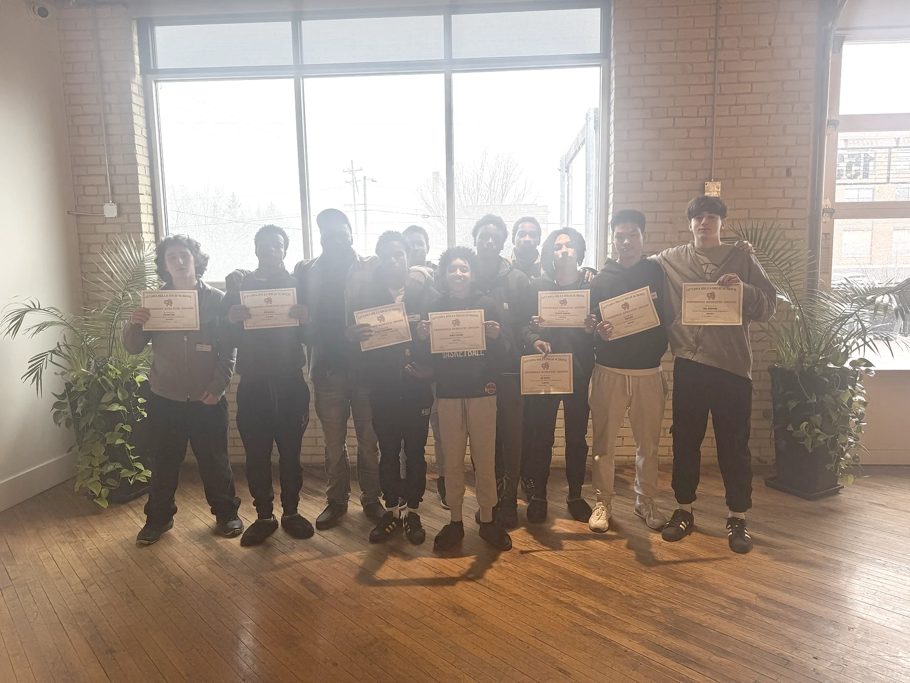 Youth participants holding certificates during a When Roses Bloom workshop
